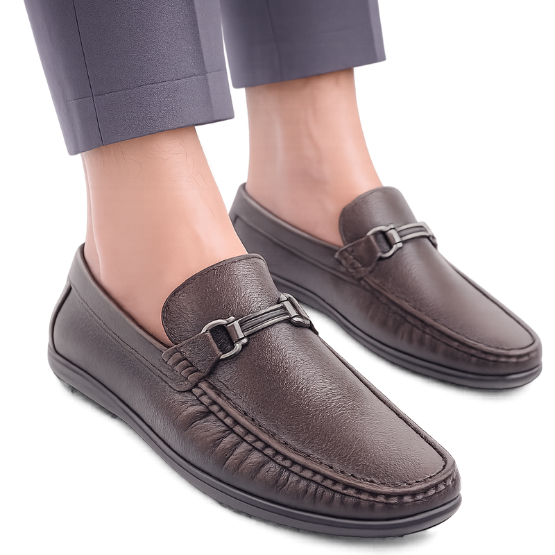 Brown loafers worn with gray pants on a white background